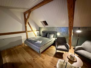 - une chambre avec un lit, une chaise et un canapé dans l'établissement Ferienwohnungen Brenner einchecken und wohlfühlen, à Langenbernsdorf