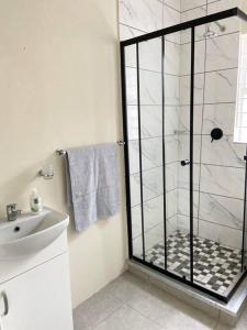 baño con ducha y puerta de cristal en Comfortably gel with the locals!, en Ciudad del Cabo