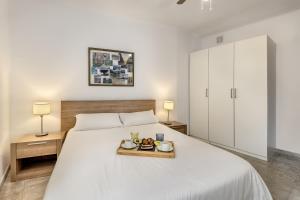 a bedroom with a bed with a tray of food on it at Flat in the old town of Alcudia in Alcudia