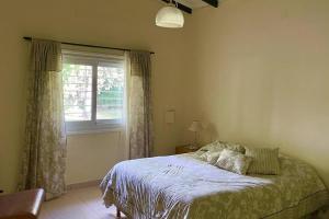 1 dormitorio con cama y ventana en Casa en Tupungato en Tupungato