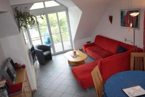 een woonkamer met een rode bank en een tafel bij Moseltraum Alte Schmiede in Schleich