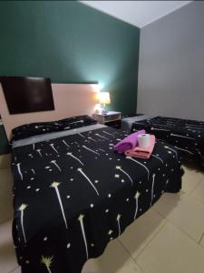ein Schlafzimmer mit einem Bett mit einer schwarzen Bettdecke und einer Tasse in der Unterkunft HOSTAL DEL SOL in Manuel Elordi