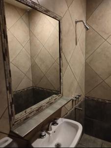 ein Bad mit einem Waschbecken und einem Spiegel in der Unterkunft HOSTAL DEL SOL in Manuel Elordi