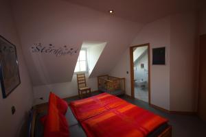 a bedroom with a red bed and a bathroom at Moseltraum Alte Schmiede in Schleich