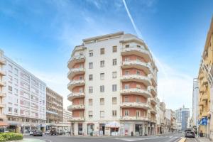 un edificio blanco alto con balcones en una calle de la ciudad en Casa Perra, en Cagliari