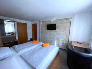 a bedroom with two beds and a brick wall at Hotel Schäffer - Steakhouse Andeo in Gemünden