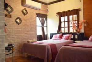 - une chambre avec 2 lits et un mur en briques dans l'établissement Cabaña/bungalow a orillas de Laguna. vacacional, à Catazajá