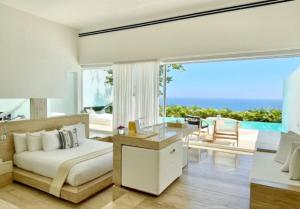 a bedroom with a bed and a view of the ocean at Encanto Acapulco in Acapulco