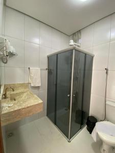 a bathroom with a shower and a sink and a toilet at Pousada Vista Bela in Mucugê