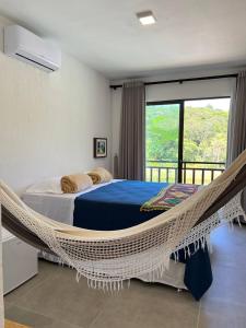 a bedroom with a hammock bed and a balcony at Pousada do lago in Guaramiranga