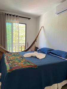 a bed with a hammock in a room with a window at Pousada do lago in Guaramiranga