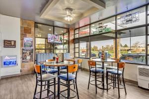 um restaurante com duas mesas e cadeiras e janelas em Clarion Inn Salt Lake City Airport em Salt Lake City