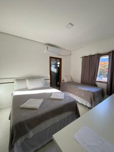 a hotel room with two beds and a window at Pousada Vista Bela in Mucugê