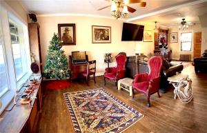 a living room with a christmas tree and red chairs at The Hotel Eastin in Kremmling