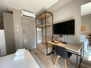 a room with a desk with a computer and a bed at Studio Completo na Haddock Lobo in São Paulo