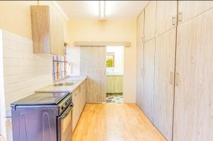 a kitchen with a purple stove and wooden cabinets at Juraya guest house in Pretoria