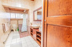 Juraya guest house في بريتوريا: حمام مع حوض ومرحاض