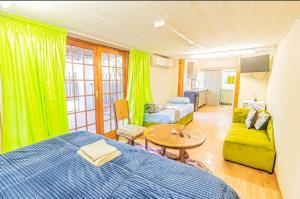 Juraya guest house في بريتوريا: غرفة نوم بسرير وطاولة واريكة