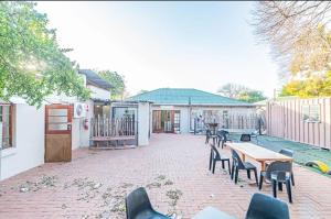 a patio with chairs and tables and a fence at Juraya guest house in Pretoria