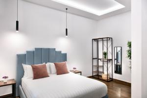 a bedroom with a white bed with a blue headboard at Residenza Toledo Lifestyle in Naples