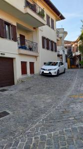 a white car parked in front of a building at Γκαρσονιέρα "Ελευθερία" Παλιά πόλη in Xanthi