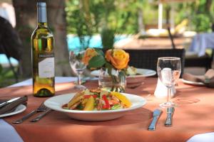 a table with a plate of food and a bottle of wine at Cresta Bosele Hotel in Selebi-Pikwe