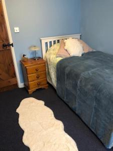 ein Schlafzimmer mit einem Bett und einem Nachttisch mit einem Bett von 6 x 6 cm in der Unterkunft Pretty cottage in the heart of Tenterden in Kent