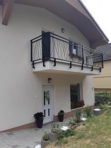 a white house with a balcony and flowers at Vilka Čachtice in Čachtice