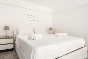 1 dormitorio blanco con 1 cama grande con sábanas blancas en La Casa di Manu, en Cornaredo