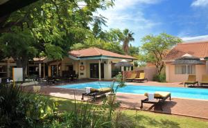 a villa with a swimming pool and a house at Cresta Bosele Hotel in Selebi-Pikwe