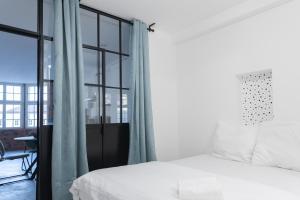 ein Schlafzimmer mit einem Bett und einem großen Fenster in der Unterkunft Grand Loft Industriel avec Vue Cathédrale Centre in Metz