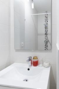 a white bathroom with a sink and a mirror at Grand Loft Industriel avec Vue Cathédrale Centre in Metz