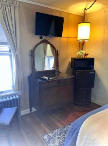 1 dormitorio con tocador con espejo y TV en la pared en The Hotel Eastin en Kremmling