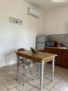 uma cozinha com uma mesa de madeira e algumas cadeiras em Az. Agricola Agriturismo Lo Schiucciolo em San Donato