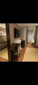 a living room with a desk and a room with a bed at Hotel Buona Vitta in Gramado
