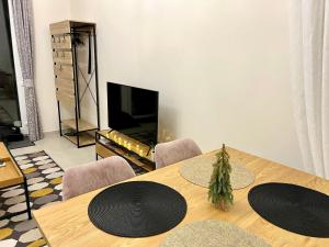 uma sala de jantar com uma mesa e uma televisão em Vörösmarty apartmanház em Makó