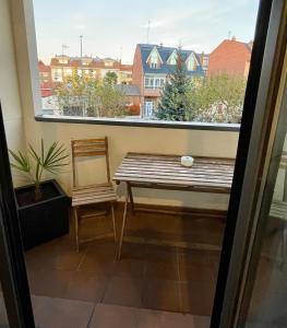 a bench and a chair in front of a window at Apartamento Entero 2 HABITACIONES in León