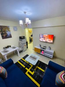 a living room with a blue couch and a tv at Homes by Essyruby in Nairobi