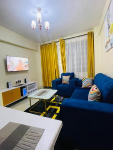 a living room with blue couches and a table at Homes by Essyruby in Nairobi