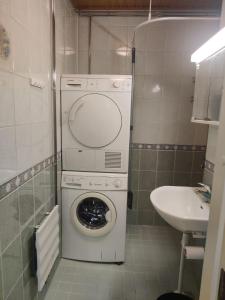 uma pequena casa de banho com uma máquina de lavar roupa e um lavatório em Tilava kaksio 4 hengelle Nokialla em Tampere