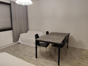 uma mesa e cadeiras num quarto com uma cama em Tilava kaksio 4 hengelle Nokialla em Tampere