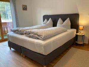 una cama con almohadas en una habitación en Ferienwohnungen Brugger, en Obermaiselstein