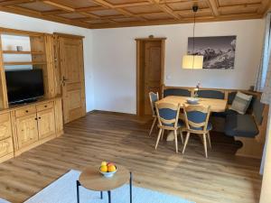 cocina y sala de estar con mesa y sillas en Ferienwohnungen Brugger, en Obermaiselstein