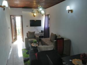 a living room with a couch and a tv at Studio meublé titi garage in Yaoundé
