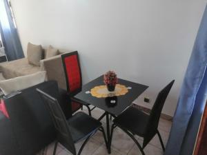 a dining table and chairs in a living room at Studio meublé titi garage in Yaoundé