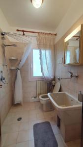 a bathroom with a tub and a toilet and a sink at NIKO casa - 3 bedroom townhouse in Ceggia
