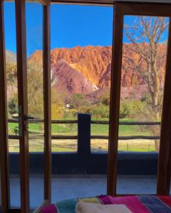 a room with a view of the mountains through a window at El cielo en Purmamarca in Purmamarca