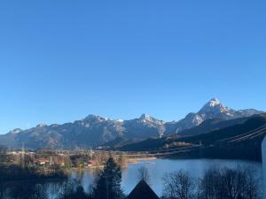 a view of a lake with mountains in the background at Pension Rexha am Weißensee in Füssen +16 photos