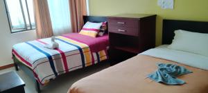 - une chambre avec 2 lits et une commode dans l'établissement Hostal Casa del Valle, 