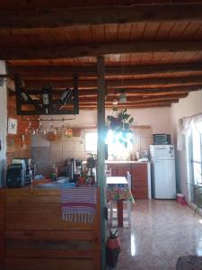 La cuisine est équipée d'une table, d'une cuisinière et d'un réfrigérateur. dans l'établissement Cabaña Sion, à Puerto Madryn